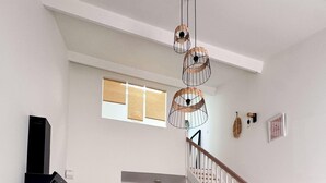 Una cocina moderna con comedor, una escalera y una sala de estar con sofá.