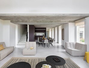 Un espacio habitable moderno con una escalera, una zona de comedor y una cocina.