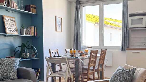 Ein gemütlicher Wohnbereich mit Esstisch, Stühlen, einer Couch und einem Couchtisch.