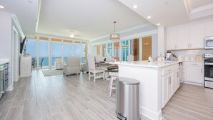 A spacious kitchen with a large island, white cabinetry, and a view to the outside. - Phoenix Gulf Towers 1005 – Beachfront Escape Lazy River & Views (Orange Beach)
