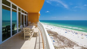 A balcony with a view of the beach, a table with chairs, and a railing. - Phoenix Gulf Towers 1005 – Beachfront Escape Lazy River & Views (Orange Beach)