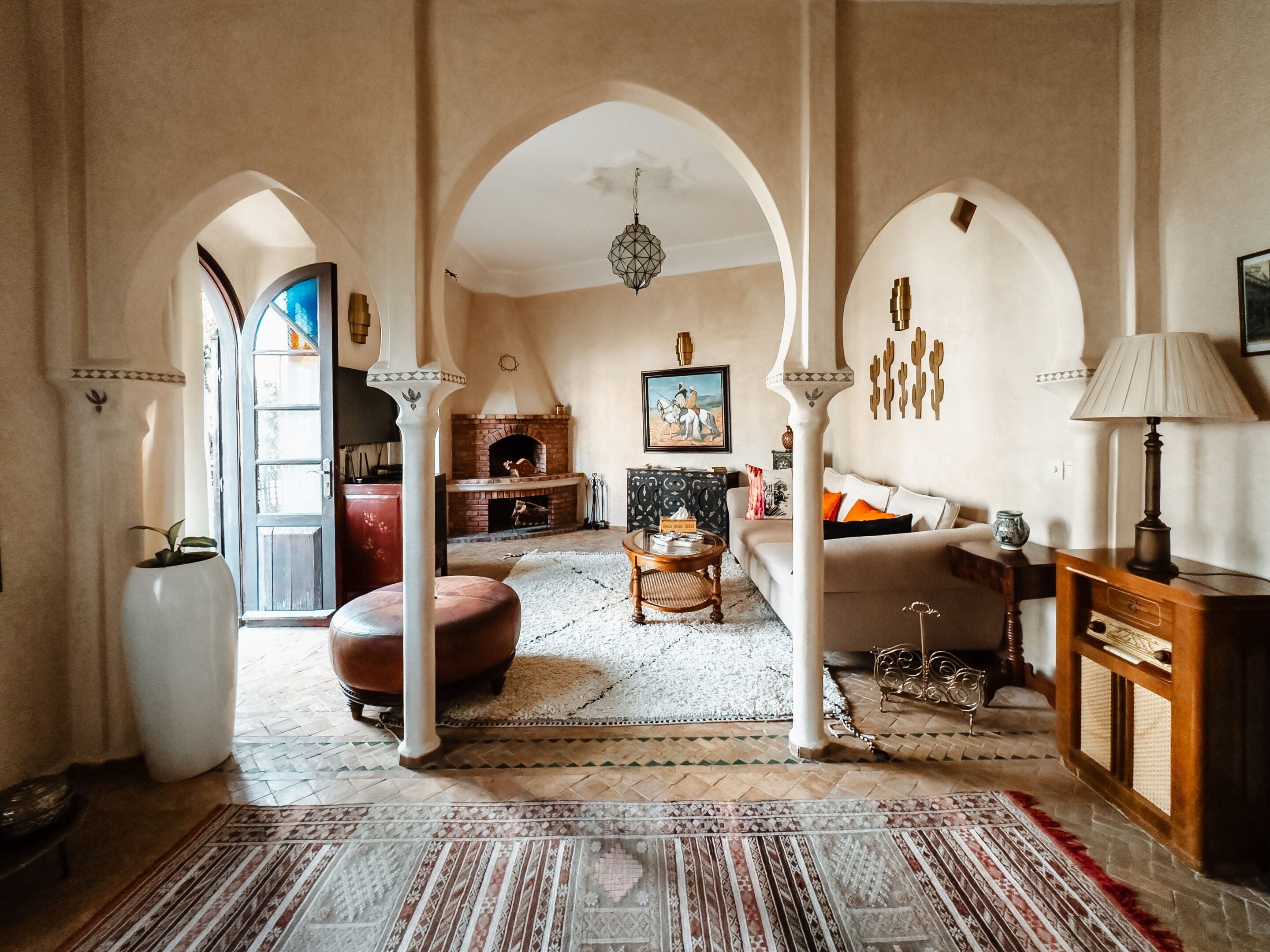 A spacious living room with a fireplace, a sofa, a coffee table, and a patterned rug.