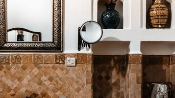 A bathroom with a mirror, a towel, a sink, and a red cabinet.
