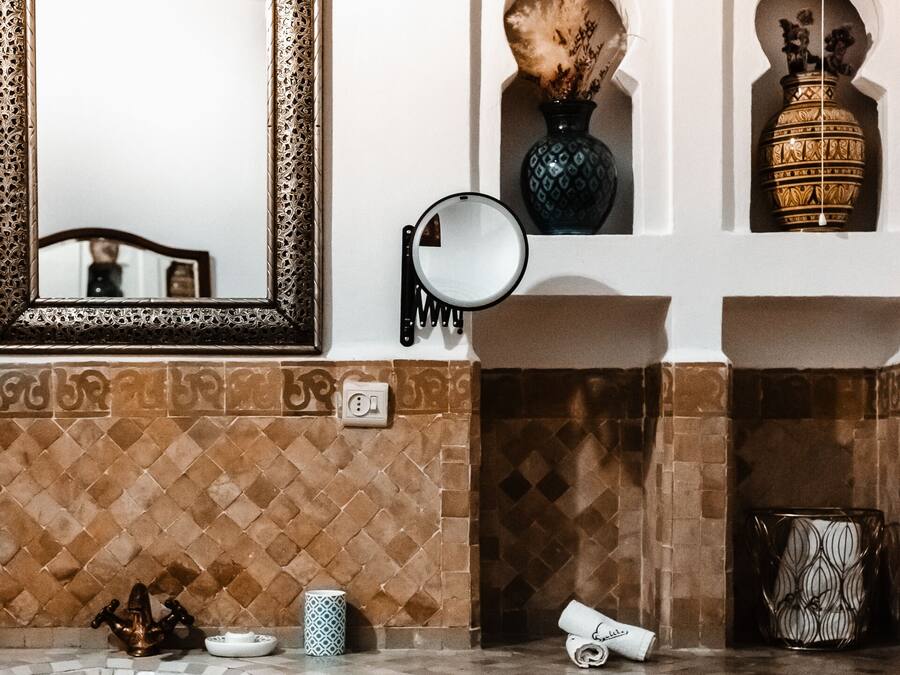 A bathroom with a mirror, a towel, a sink, and a red cabinet.