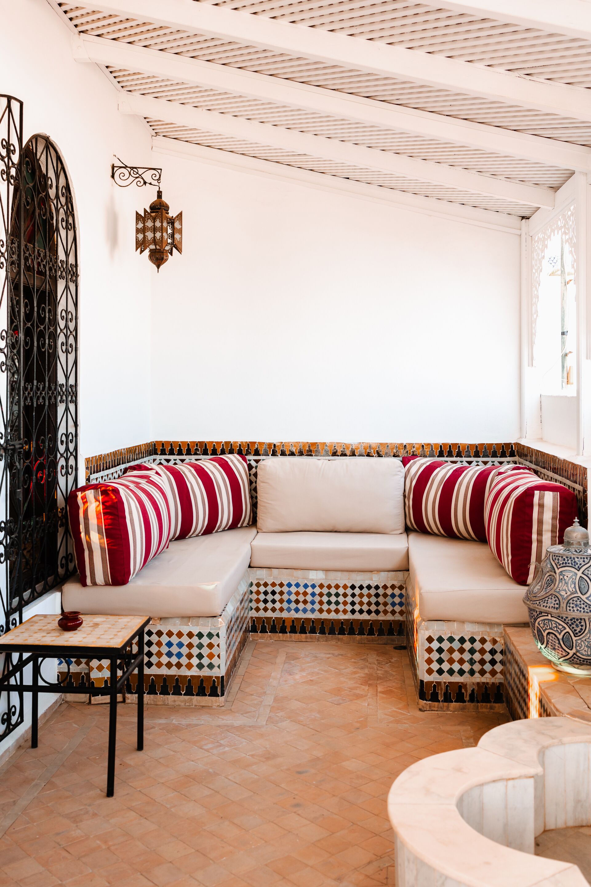 A cozy seating area with a cushioned sofa, a patterned floor, and a decorative lantern.