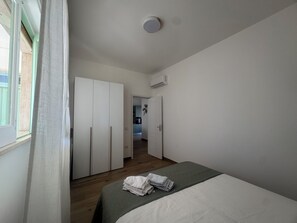 Una camera da letto con un letto, un armadio e una porta che dà su una cucina.