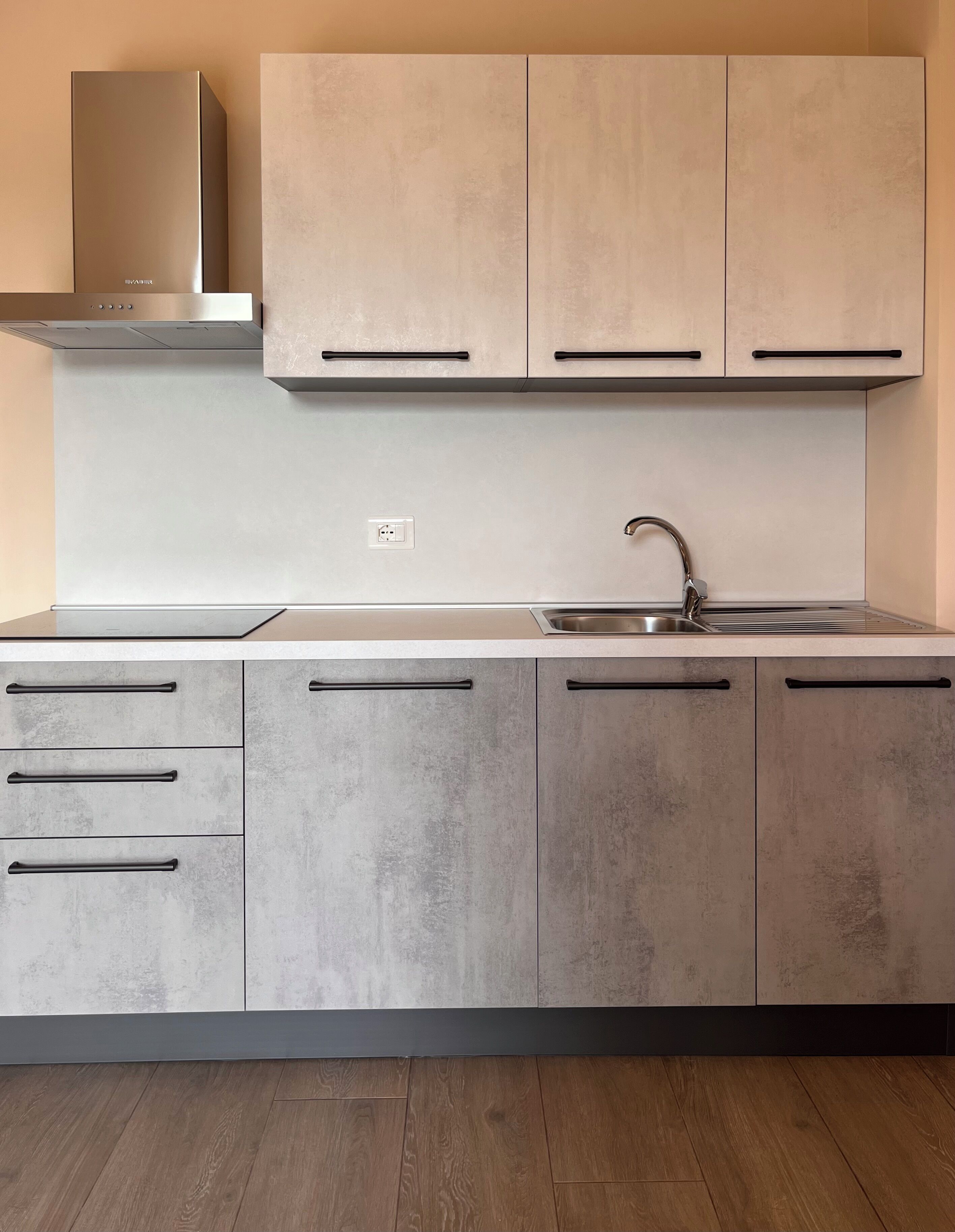 A modern kitchen with a built-in stove, a sink, and cabinets.