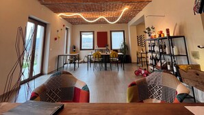 Una sala de estar moderna con techo de ladrillo, un comedor y una estantería.