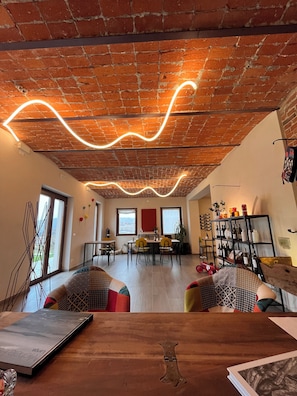 Un espacio moderno para vivir con techo de ladrillo, zona de comedor y estantería.