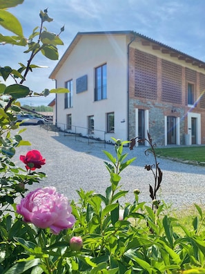 A two-story building with a flat roof, large windows, and a gravel driveway. - Le Cornici - Homes (Piemonte)