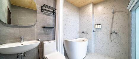 A modern bathroom with a freestanding bathtub, a sink, and a shower.