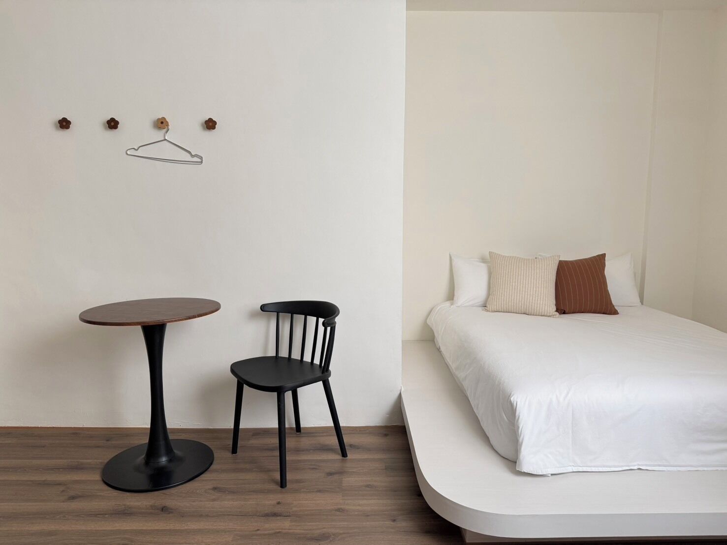 Une pièce comprenant un lit, une petite table ronde et une chaise.