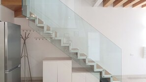 A modern kitchen with a glass staircase, stainless steel appliances, and a minimalist design. - casa Anna by Ca-sa Check (Montichiari)