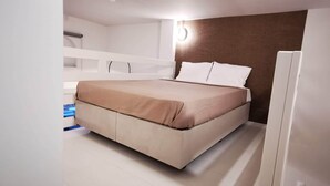Ein Schlafzimmer mit einem Bett, einem weißen Kleiderschrank und einer weißen Bank.
