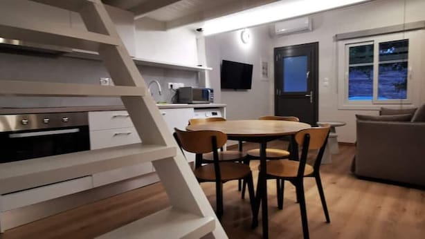 Eine moderne Küche mit Essbereich, einer Treppe und einem Fenster mit Blick.