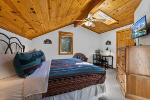 A bedroom with a bed, a desk, a chair, a wardrobe, and a ceiling fan. - Riverfront Condo • Fireplace • Close to RMNP (Estes Park)