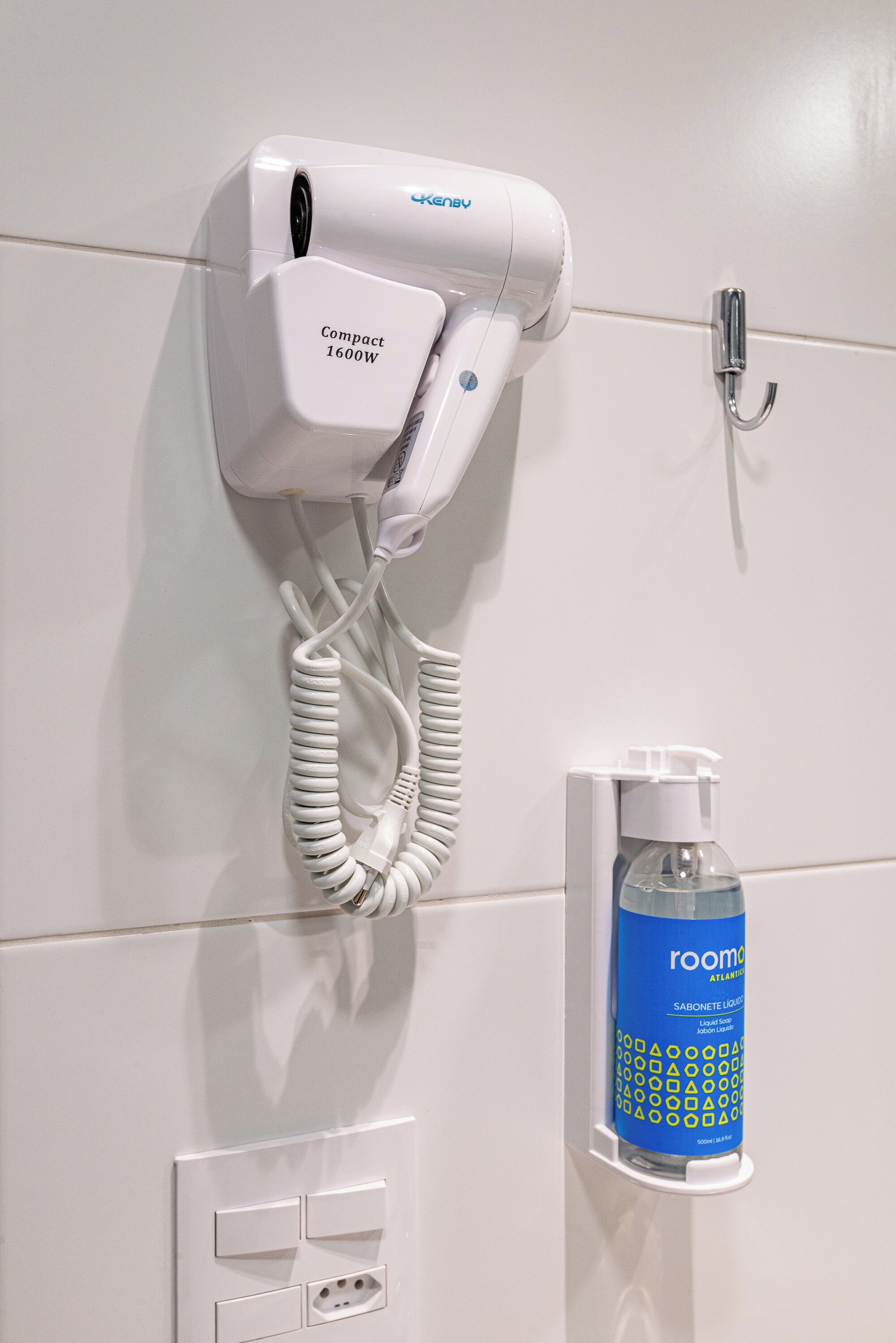 A compact hair dryer, a bottle of room spray, and a wall-mounted hairdryer with a USB charging port.