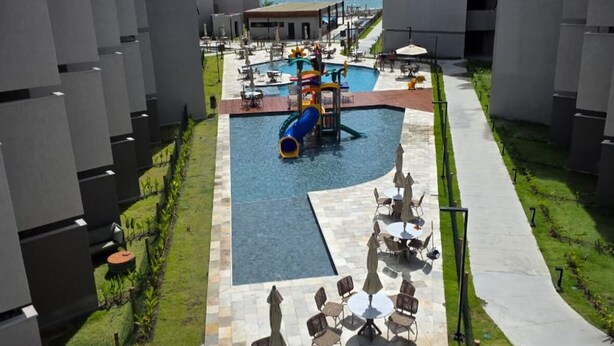 Et resort med swimmingpool, vandrutsjebaner og udendørs siddepladser.