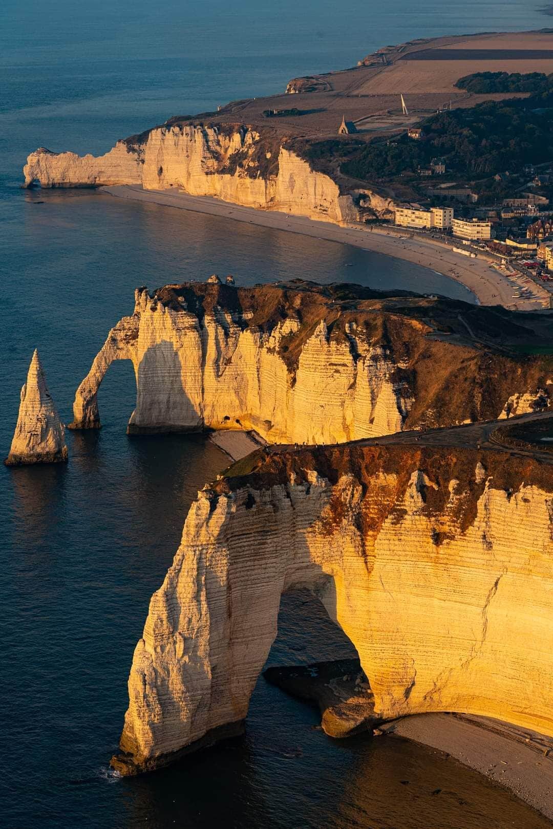 Un paysage côtier caractérisé par d’imposantes falaises blanches et une plage.