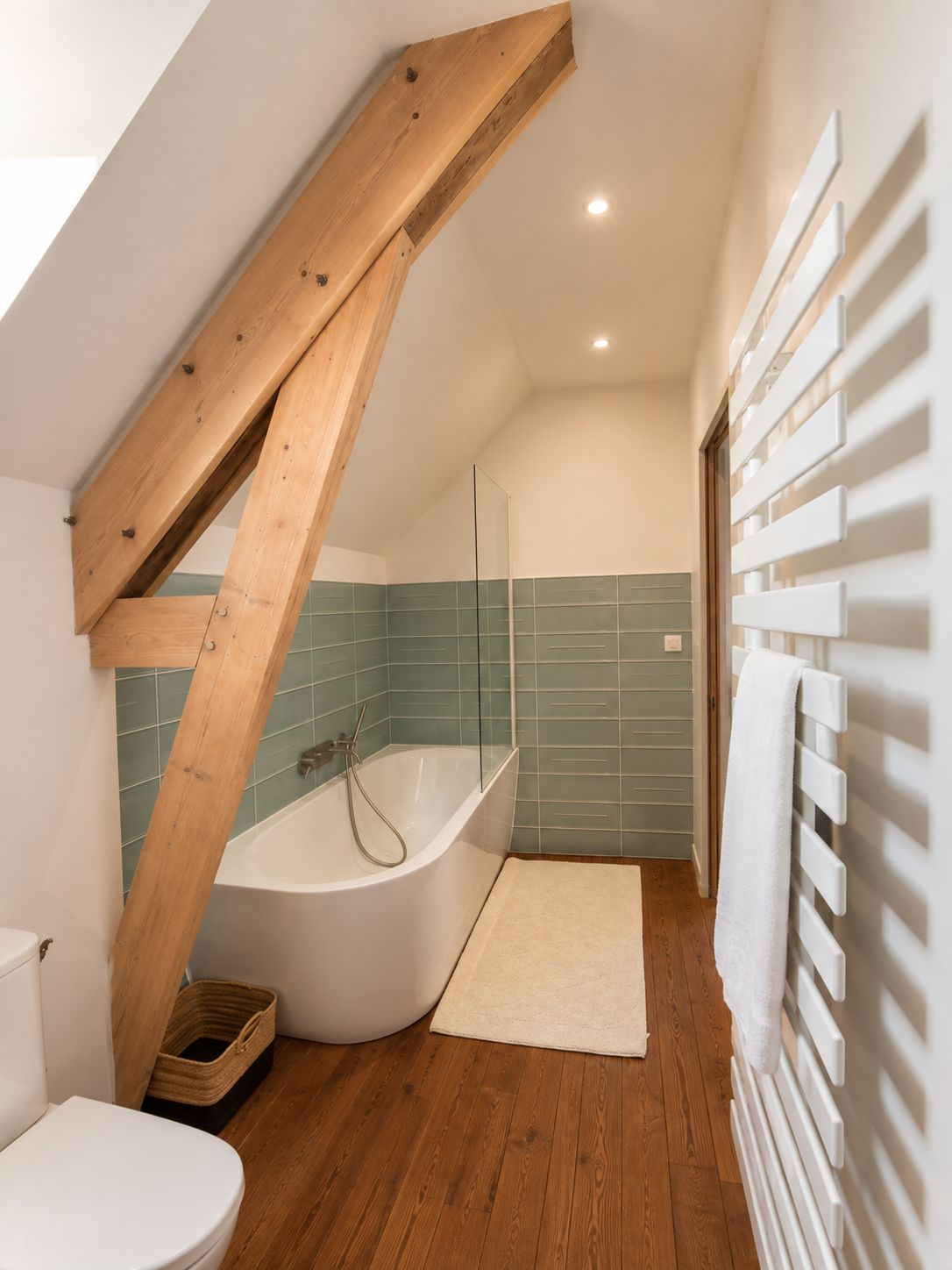 Ein Badezimmer mit einer Holztreppe, einer Badewanne, einer Dusche und einem weißen Heizkörper.