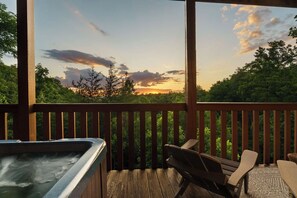 A hot tub on a wooden deck with a view of trees and a sunset. - Epic Views•Hot Tub•Game Room•Private•Near PF, Gatlinburg & GSMNP (Sevierville)