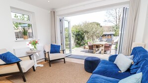 Een moderne woonkamer met een bank, stoelen, een bijzettafeltje en uitzicht op de omgeving.