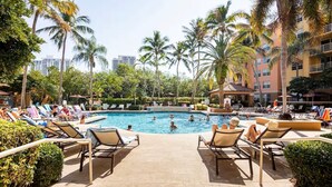 Ein Poolbereich mit Liegestühlen und Palmen.