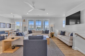 Ein modernes Wohnzimmer mit Sofa, Couchtisch und Fernseher.