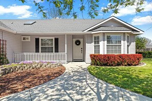 A single-story house with a front porch, a door with a wreath, and a well-maintained lawn. - Luxe Meridian Retreat •1K+3Q beds • 600+ WiFi • 3 Desks • Games • Prime Location (Meridian)