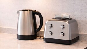 A kitchen counter with a stainless steel kettle and a toaster. - Modern 1BR Ground Floor Flat | City Centre Near High Street (Southend-on-Sea)