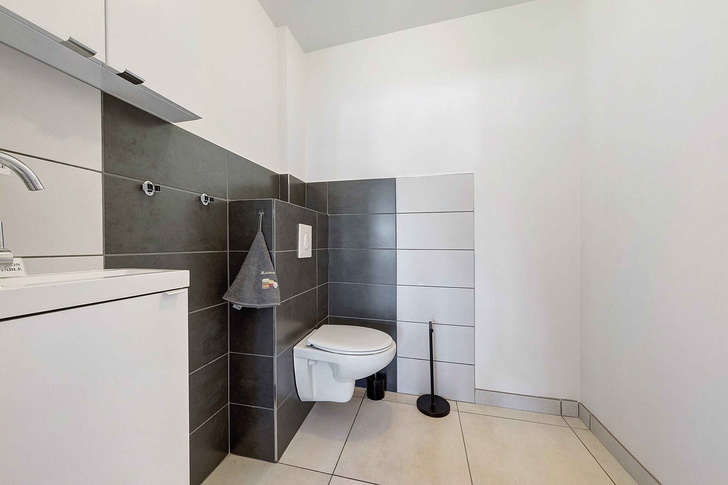 A modern bathroom with a toilet, sink, and shower area.