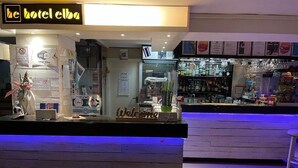 A hotel reception desk with a 'Welcome' sign, a Wi-Fi symbol, and a bar area with various bottles and glasses. - hotel elba (Rivazzurra)
