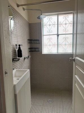 A bathroom with a shower, a sink, and a window with decorative glass. - Private Studio Near Condesa, Roma & Chapultepec (Ciudad de México)