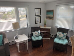A room with two wicker chairs, a white table, and a small white cabinet. - Ocean side 6 houses to the beach; 4 bed with full SUNSET views (Beach Haven)