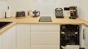 Cozinha equipada com torradeira, máquina de café e lava-louças.