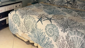 A bedroom with a bed, a dresser, a nightstand, a lamp, and a wall with three framed pictures. - Walk to Beach! Private Heated 3 bedroom Pool Home (Naples)
