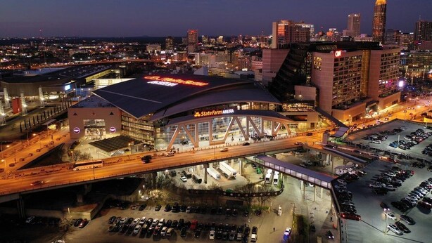 Kaupunkikuva, jossa näkyy selvästi erottuva rakennus, jonka kyltissä lukee ”State Farm Arena”, sekä parkkipaikka.