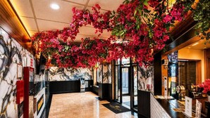 A hotel lobby with marble walls, a reception desk, and a black reception area. - Imperial Hotel (Brooklyn)