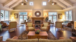 A spacious living room with a fireplace, multiple seating areas, and large windows. - Orlando | Couples Theme Park Escape | Pool + Hot Tub (Orlando)