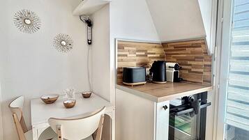Een koffiezetapparaat/waterkoker, een koelkast, een oven, een vaatwasser
