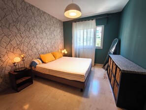 A bedroom with a bed, bedside lamps, a nightstand, a mirror, and a window with curtains. - Apartment with Panoramic Sea View (Ajaccio)