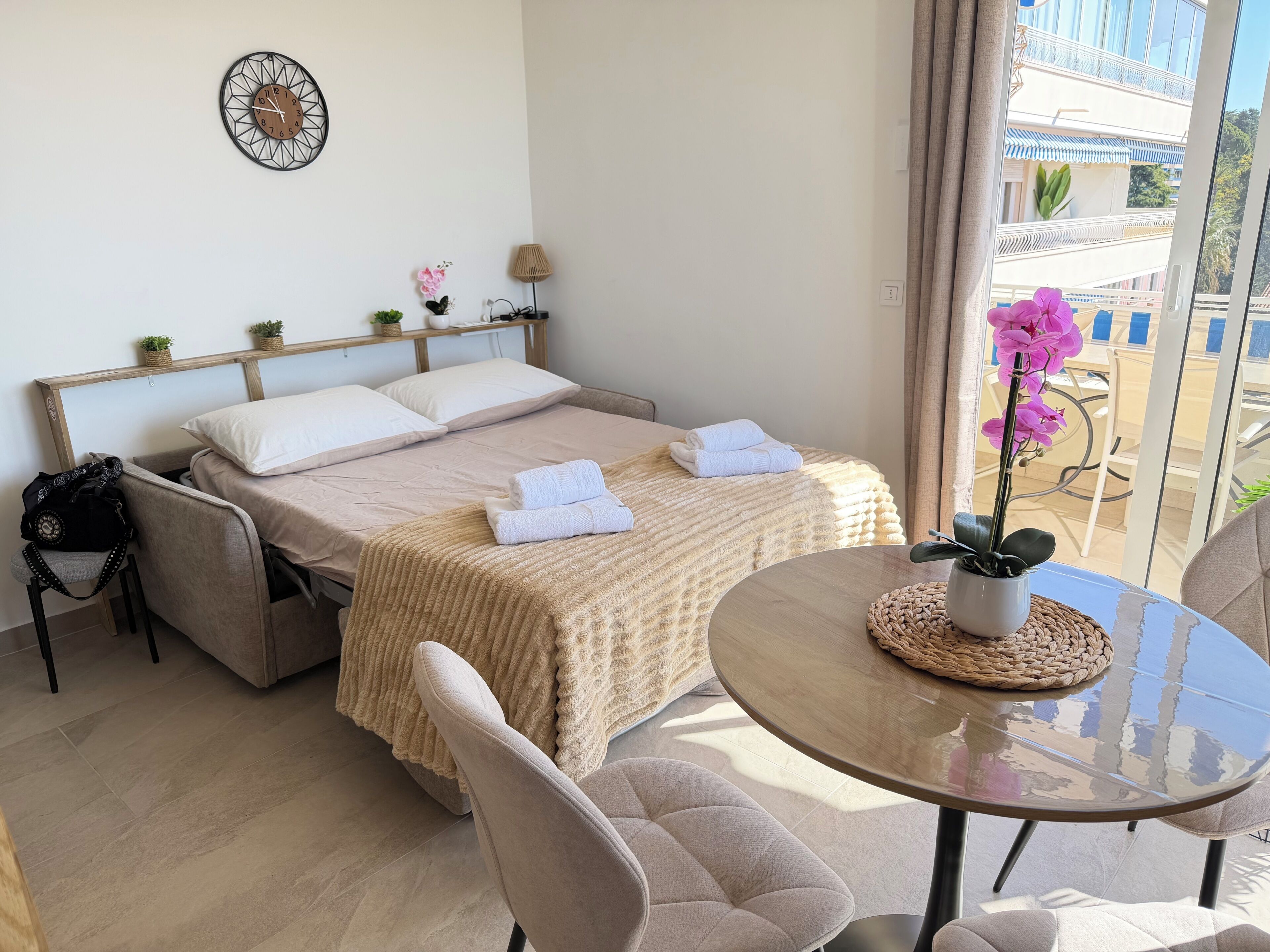 Une chambre d’hôtel avec un lit, deux oreillers, une table de chevet avec une lampe, une chaise et une vue sur l’extérieur.