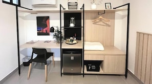 Ett litet rum med ett skrivbord, en stol och en säng.