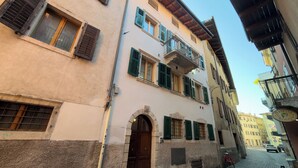 A narrow cobblestone street flanked by historic buildings with arched doorways and traditional shutters. - Soul of Trento Vicolo Maddalena (Trento)