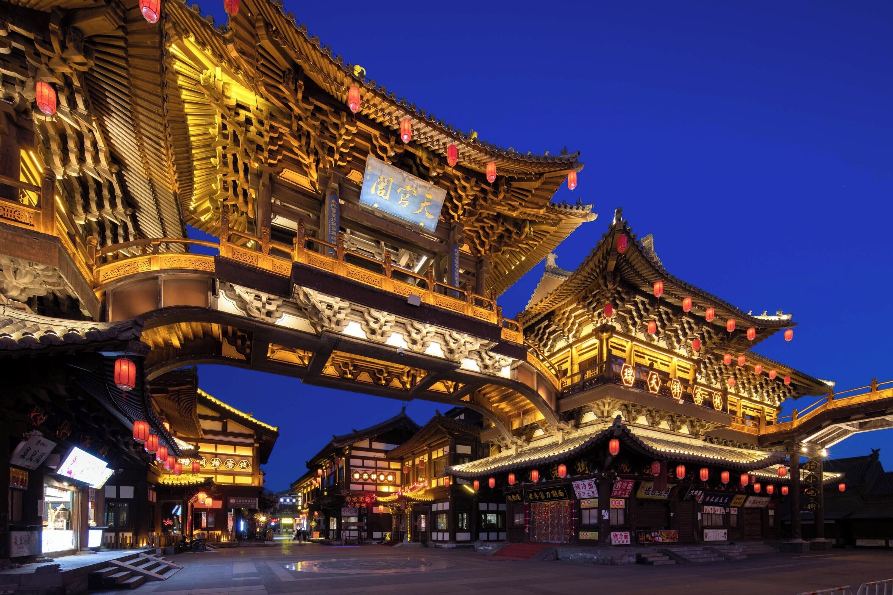 A traditional building with ornate architecture, a signboard, and red lanterns.