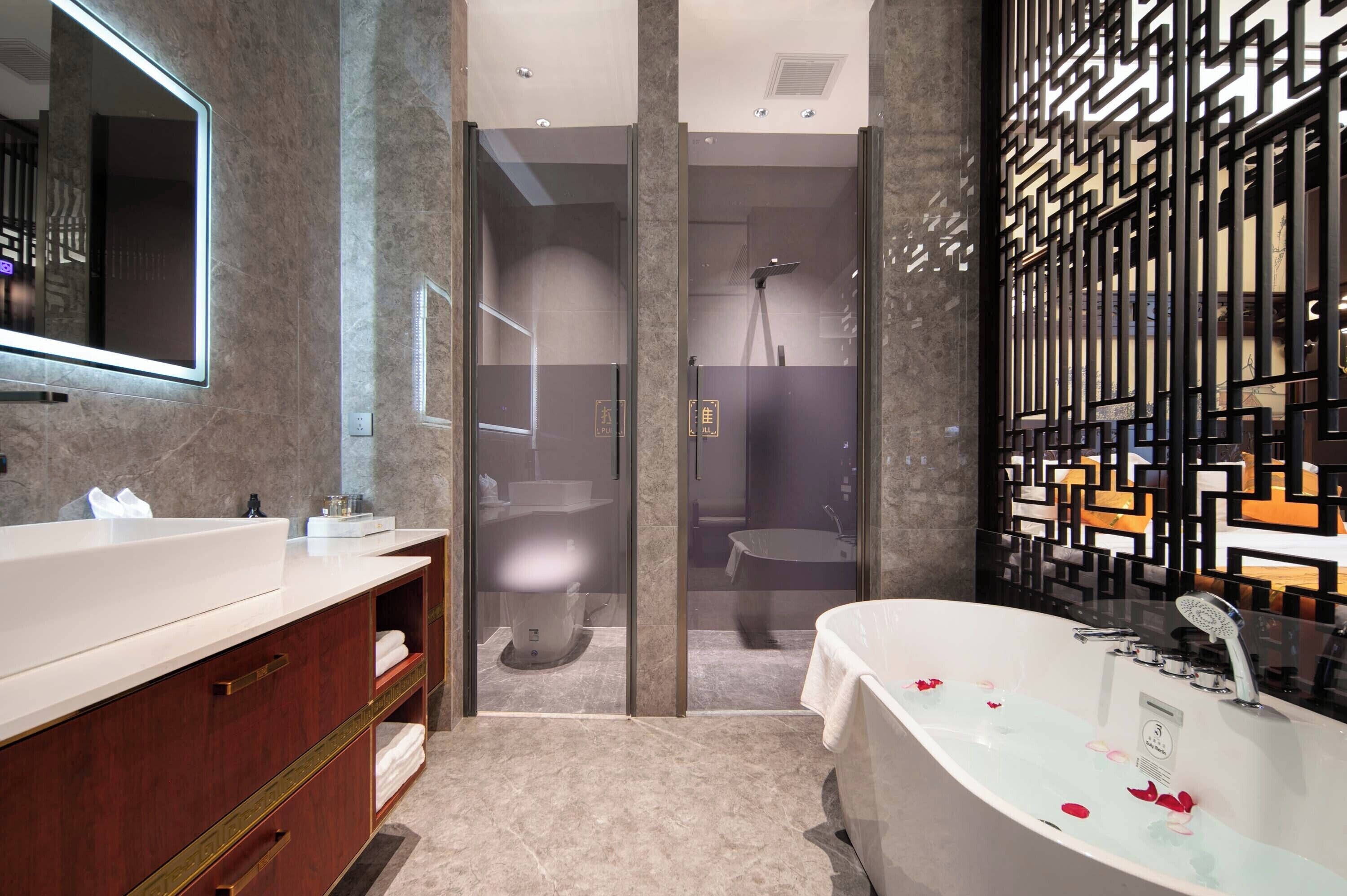 Une salle de bain moderne avec une grande baignoire, un meuble-lavabo avec un miroir et un espace douche.