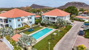 A resort with a swimming pool, multiple-story buildings, and a parking area. - Luxury New 2BR Apartment near Blue Bay Beach, 20m Pool, Sleeps max 4 (Sint Michiel)