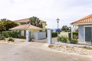 A gated residential area with a paved entrance, a street lamp, and a blue parking sign. - Luxury New 2BR Apartment near Blue Bay Beach, 20m Pool, Sleeps max 4 (Sint Michiel)