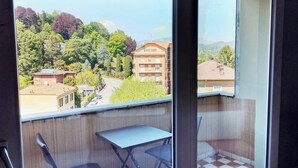 Un balcón con vista a una zona residencial, una mesa y una silla.