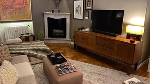 Una sala de estar con chimenea, televisor, sofá y una mesa de centro.